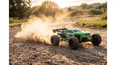 A green hobby-grade RC stadium truck kicking up dirt while speeding along an outdoor track.