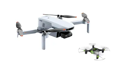 Studio shot of two different beginner drones against a plain white background, featuring a larger grey foldable drone and a smaller mini drone.