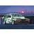 Box art illustration of a green and white Toyota AE86 Levin race car with Trampio livery parked at a track during sunset.