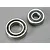Two metal ball bearings of different sizes sitting on a grey surface.