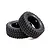 Two black Tamiya 1/10 scale mud block RC tyres shown from an angle against a white background.