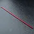 A red anodized aluminium centre driveshaft for an RC car, shown against a dark textured background.