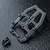 A black MST front head set component for an RC car chassis, shown on a dark textured surface.
