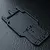 Black MST RMX series RC car rear lower deck chassis plate on a dark textured surface.