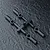 Four black plastic RC rod ends attached to a sprue tree on a dark textured background.
