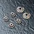 A set of six metal differential bevel gears of varying sizes arranged on a dark textured surface.