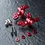 Two red anodized aluminium MST ATK V3 steering hubs with included screws, spacers, and pins on a textured dark surface.