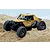 UDI UCX24 Snow Leopard 1/24 scale yellow RC rock crawler parked on sandy terrain outdoors.
