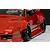 Close-up of a red RC car body installed with wide over fender flares and black wheels on a marble surface.