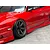 Close-up of a red RC drift car body showing the front wheel, side skirts, and painted body details.