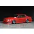 Red RC drift car body shell mounted on a chassis with chrome wheels against a black and grey studio background.