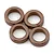 A close-up studio shot of four copper-coloured metal bushings arranged in a cluster against a plain white background.