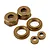 A set of gold-coloured aluminium shock caps and associated small threaded components for RC vehicles on a white background.