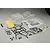 An unpainted clear polycarbonate RC crawler body shell kit with black plastic roll cage parts, light buckets, and decal sheets on a grey background.