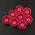 Eight fluorescent pink multi-spoke RC car rims arranged on a dark textured surface.