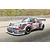 A silver Porsche Carrera RSR Turbo race car with Martini Racing livery and number 21, shown in motion on a racetrack.