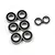 A collection of eight rubber-shielded metal ball bearings of varying sizes arranged on a white background.