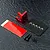 MST red aluminium ESC mount with carbon fibre plate, double-sided tape, and screws on a textured black surface.