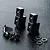 Two black aluminium servo mounts with included screws and washers on a textured black surface.