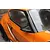 A close-up view of a black aero side mirror mounted on an orange RC car body shell.