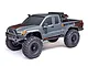 Axial SCX10 III Base Camp 4X4 RC rock crawler in grey with orange topographical graphics, black wheels, and off-road tires on a white background.