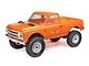 An orange Axial SCX24 1967 Chevrolet C10 RC rock crawler truck viewed from a front three-quarter angle against a white background.