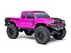 A studio shot of the pink Axial SCX24 Base Camp 1/24 scale RC rock crawler truck on a white background.