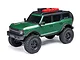 Axial SCX24 2021 Ford Bronco RC rock crawler in green, featuring a roof rack with accessories, black wheels, and off-road tires against a white background.