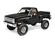 A black Axial SCX10 III Base Camp 1982 Chevrolet K10 RC rock crawler truck on a white background.