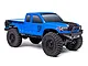 A studio shot of the blue Axial SCX24 Base Camp 1/24 scale RC rock crawler truck on a white background.