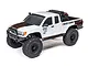 A white Axial SCX10 III Base Camp 4X4 RC rock crawler truck with black trim, off-road tires, and topographic decal details on a white background.