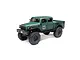 Axial SCX24 Dodge Power Wagon RC rock crawler in green, featuring a detailed truck body, large off-road tires, and black wheels on a white background.