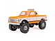 Axial SCX24 1/24 scale 1967 Chevrolet C10 RC rock crawler truck in orange and white, featuring a chrome roll bar with off-road lights.