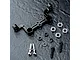 MST black aluminium steering joint plate with included bearings, screws, and spacers on a dark textured surface.