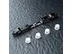 A black MST aluminium adjustable lower suspension arm mount with four small white plastic inserts on a dark textured surface.