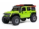 Studio product photo of a bright green Axial Jeep Wrangler RC rock crawler with roof rack and accessories on a white background.