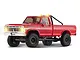 Studio product shot of the FMS FCX18 II Ford F-100 RC Rock Crawler in red with illuminated headlights and roof lights.