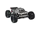 Studio shot of the ARRMA Outcast BLX 1/8 scale RC truggy in grey, featuring large off-road tires, a roll cage, and a detailed truck body.