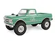 A green 1/24 scale Axial SCX24 1967 Chevrolet C10 RC rock crawler truck viewed from a front three-quarter angle against a white background.