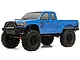 A blue Axial SCX10 III Base Camp 1/10 scale RC rock crawler truck viewed from a front three-quarter angle against a white background.
