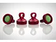 Four red anodized aluminium shock caps with green rubber seals, arranged on a white reflective surface.