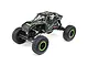 Axial UTB18 Capra 1/18 scale RC rock crawler in black with green accents, featuring a tube chassis, off-road tires, and detailed driver figures.