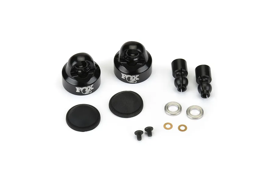 Two black aluminium Pro-Line Fox shock caps with associated rubber diaphragms, pivot balls, washers, and small screws on a white background.