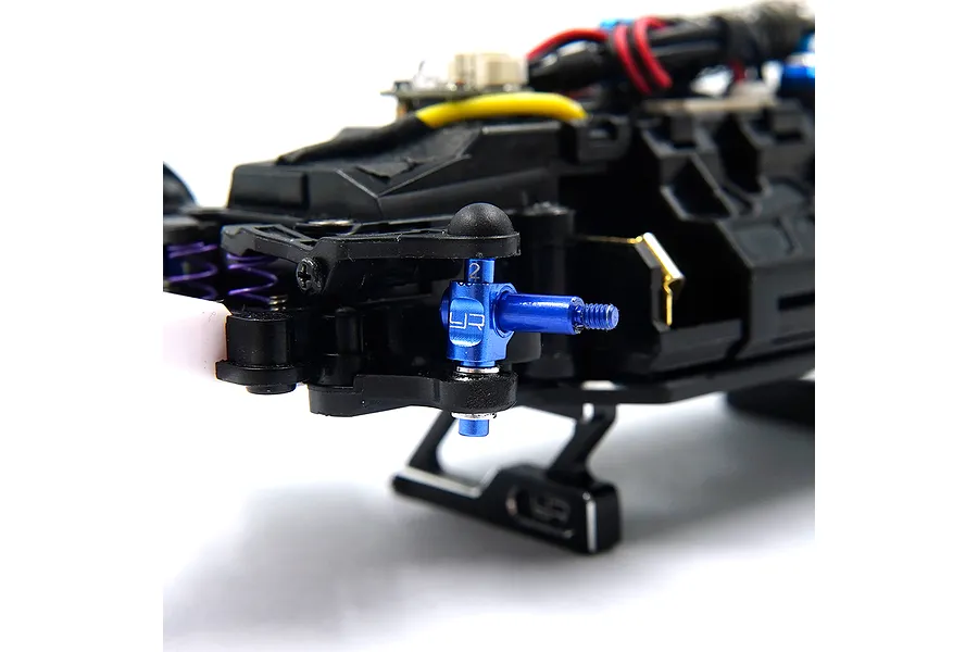 A blue anodized aluminium steering knuckle installed on an RC car chassis, featuring the Yeah Racing logo and a number 2 marking.