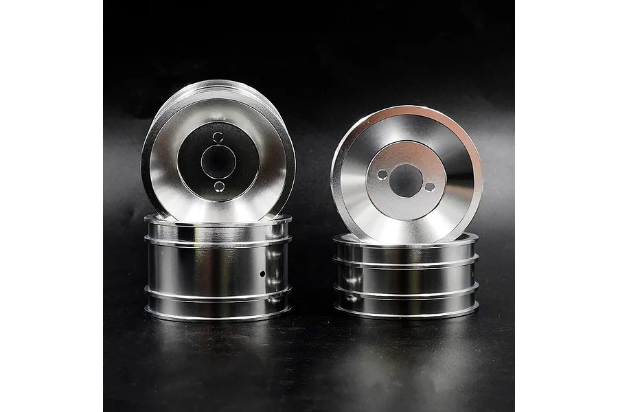 Four silver aluminium RC car rims arranged in two stacks against a black background.