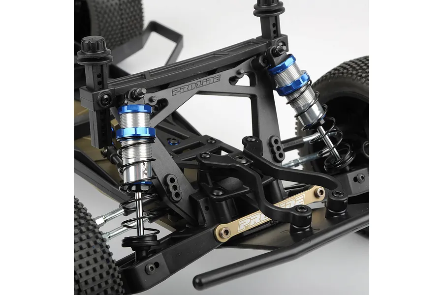 Close-up of Pro-Line Pro-Spec shock absorbers installed on an RC vehicle chassis, featuring blue anodized caps and silver bodies.