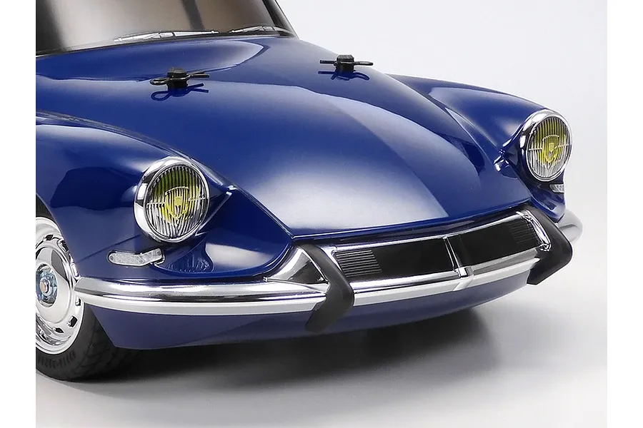 Close-up of the front end of a blue Tamiya Citroen DS RC car model on a white background.