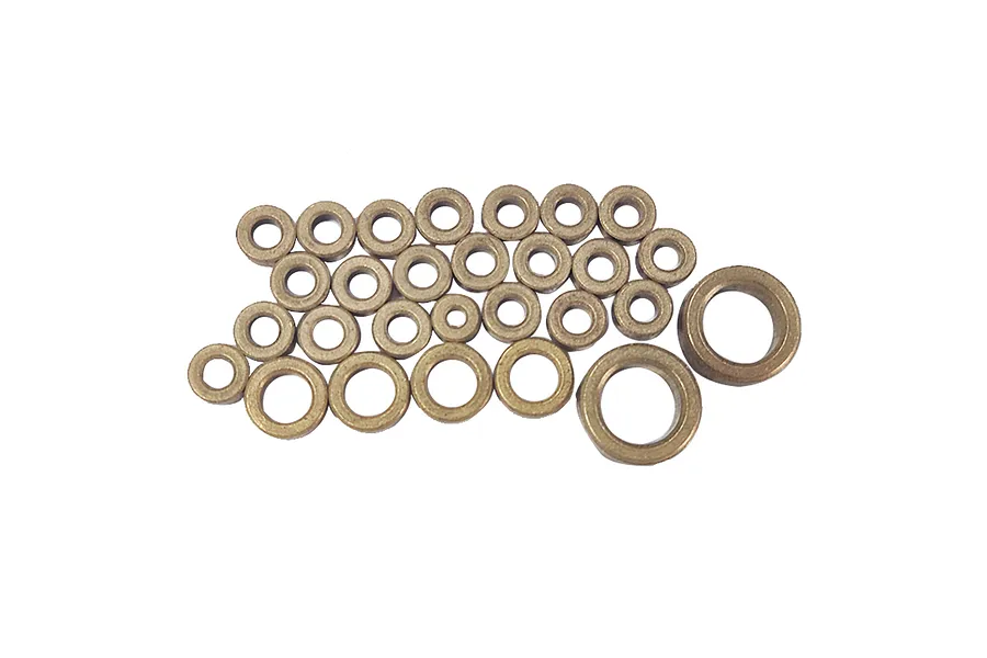 A collection of various sized bronze-coloured metal bushings arranged on a white background.