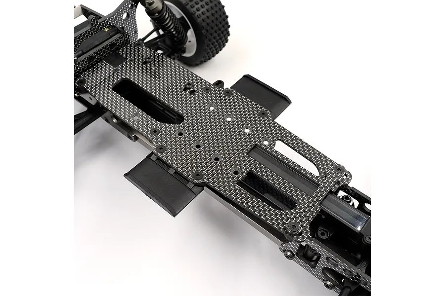 A close-up view of a carbon fibre RC car chassis upper deck installed on a vehicle frame.
