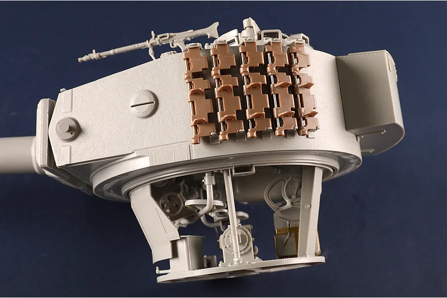 A close-up view of a 1/16 scale Tiger I tank turret model showing internal turret details and external track links mounted on the side.